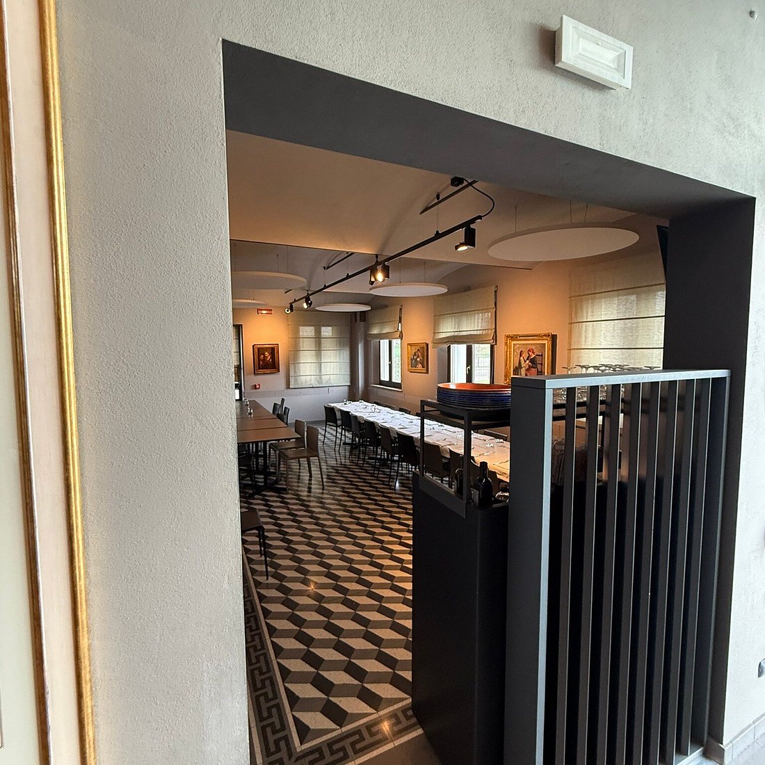 Sala ristorante con pavimento a scacchi e specchio con cornice dorata